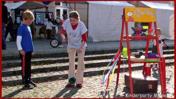 Kinderfest · Animateurin zeigt Kind Diabolo Spiel