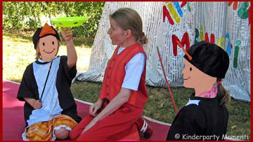 Zirkus zum Mitmachen - Kinder mit Pinguin Kostüm sitzen vor Zirkusvorhang und drehen Teller